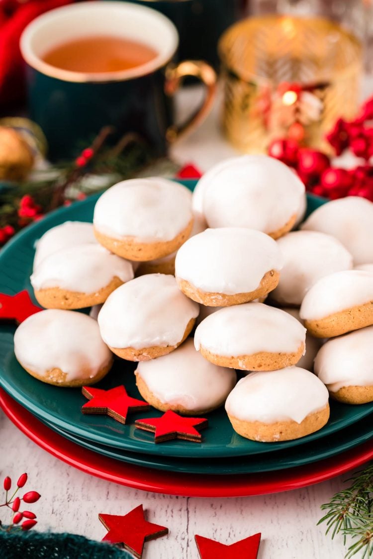 Close up photo of pfeffernusse cookies piled on a teal plate.