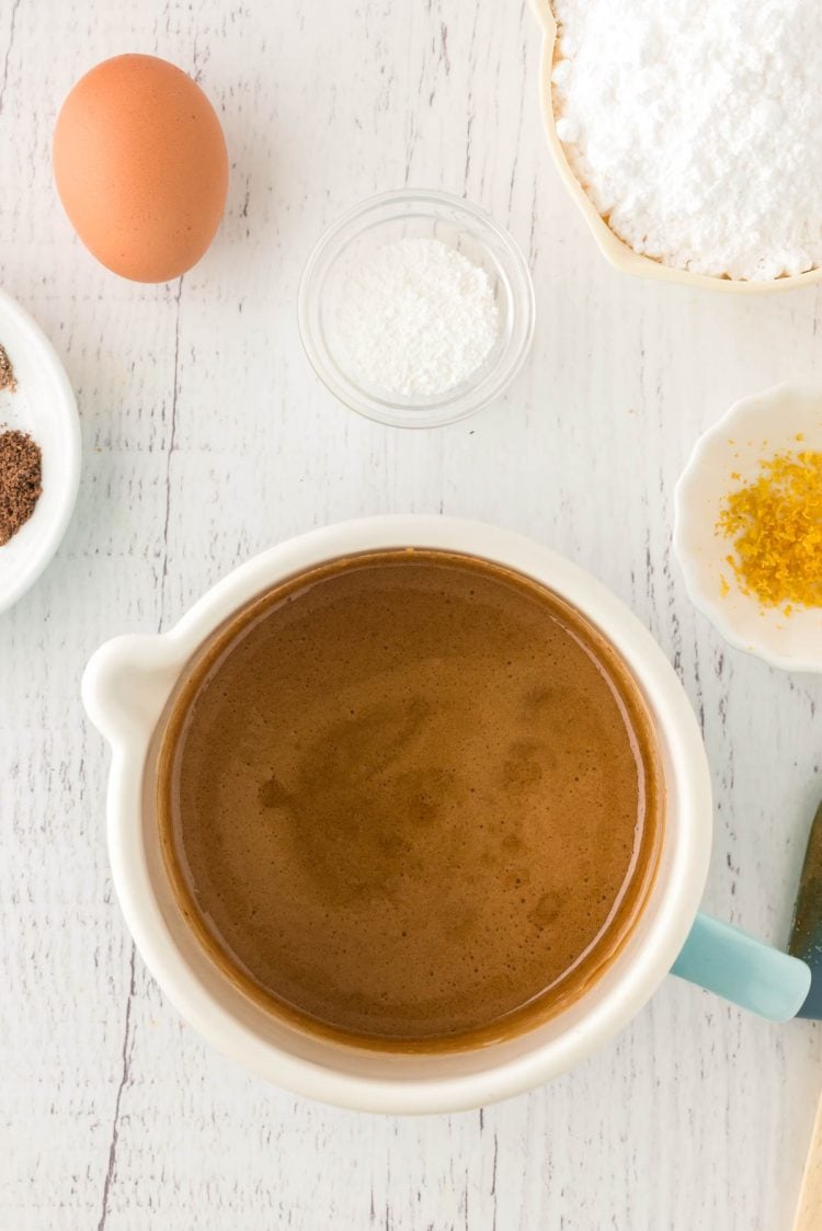 Overhead photo of a pot with melted brown sugar and honey in it with other ingredients around it.