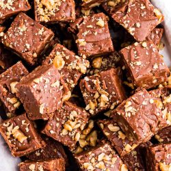 Overhead photo of a bunch of pieces of walnut chocolate fudge on a plate.