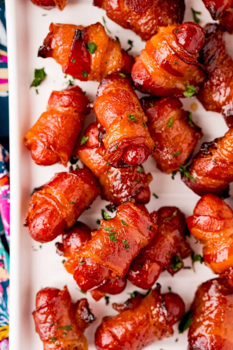 Overhead photo of bacon-wrapped little smokies on a white plate.