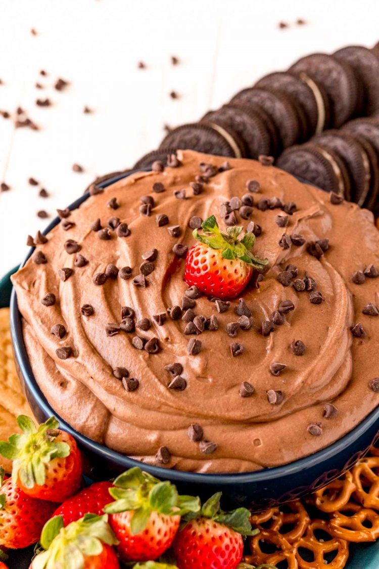 A bowl of brownie batter dip with a strawberry in it.