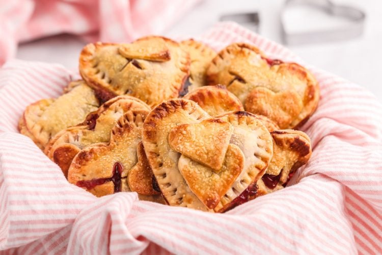 Close up photo of heart shaped hand pies on a white and pink striped napkin.