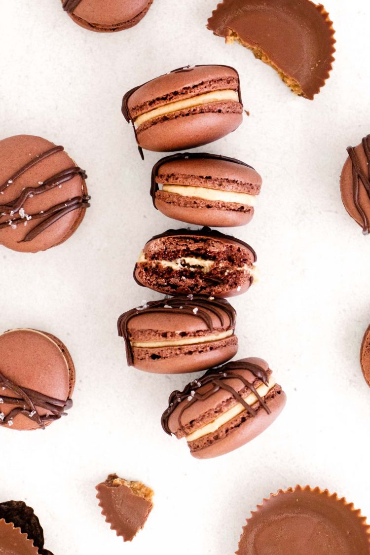 Overhead photo of peanut butter chocolate macarons on a white surface.