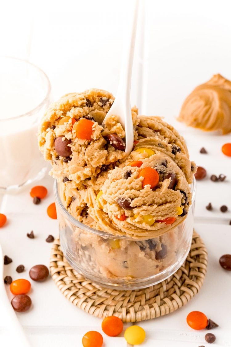 Edible cookie dough with a white spoon sticking out of the bowl.