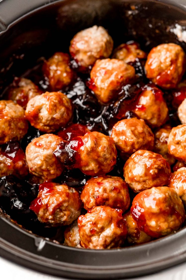 Meatballs in a crockpot with grape jelly.