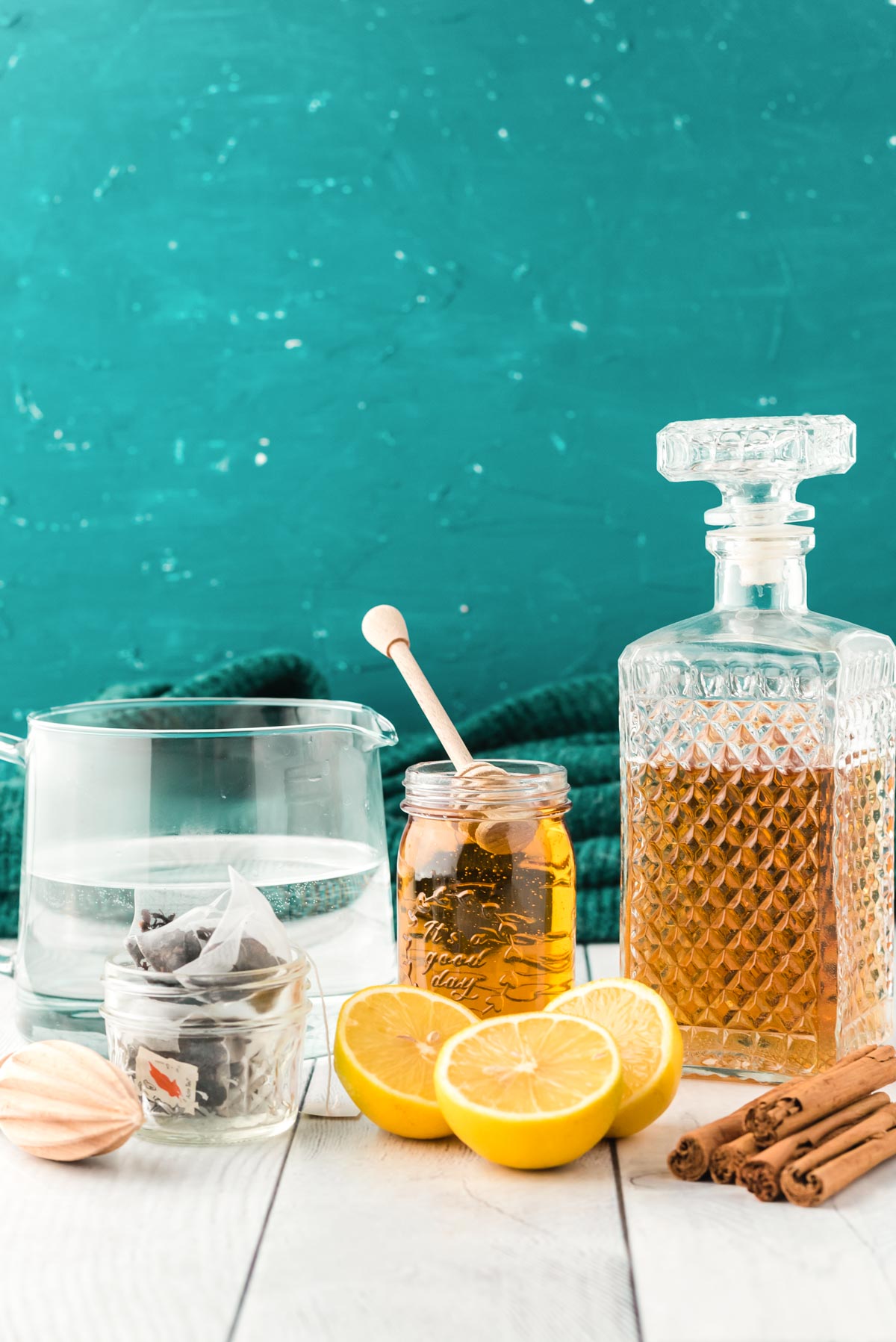 Ingredients to make a hot toddy on a white wood table.