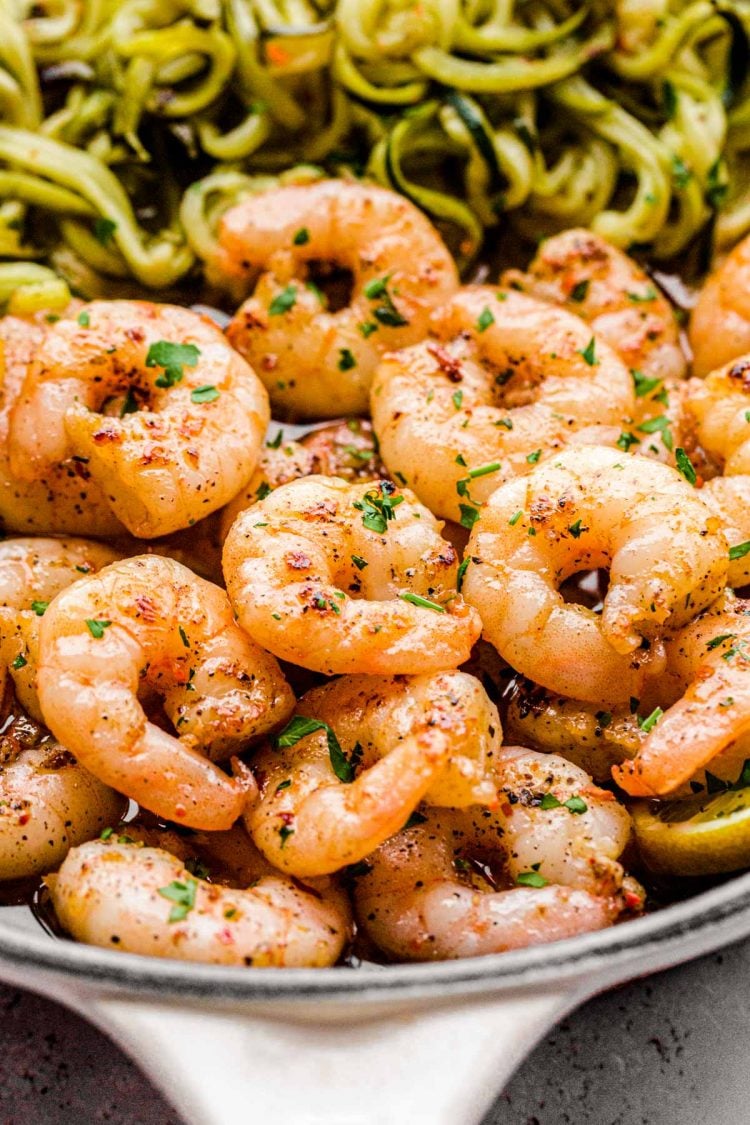 Close up photo of garlic lemon shrimp with zucchini noodles in a skillet.