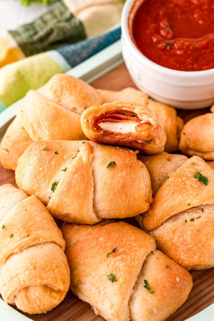 Pizza rolls piled on each other on a serving board.
