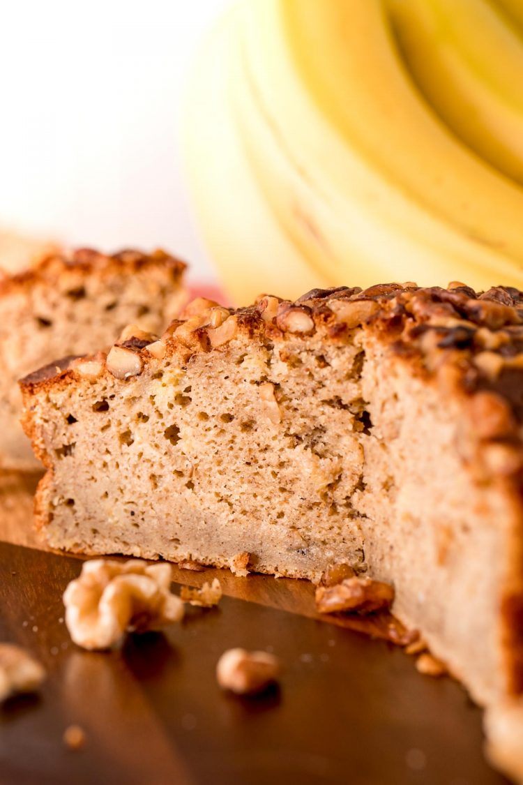 Close up photo of a round loaf of air fryer banana bread with some slices taken out so you can see the texture of the inside.