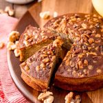 A round loaf of banana bread that's been cooked in the air fryer on a wooden cutting board.