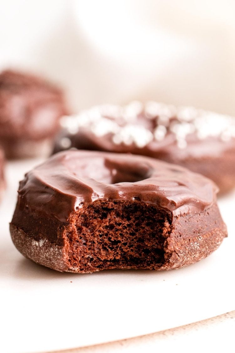 Close up photo of a chocolate donut with a bite taken out of it.