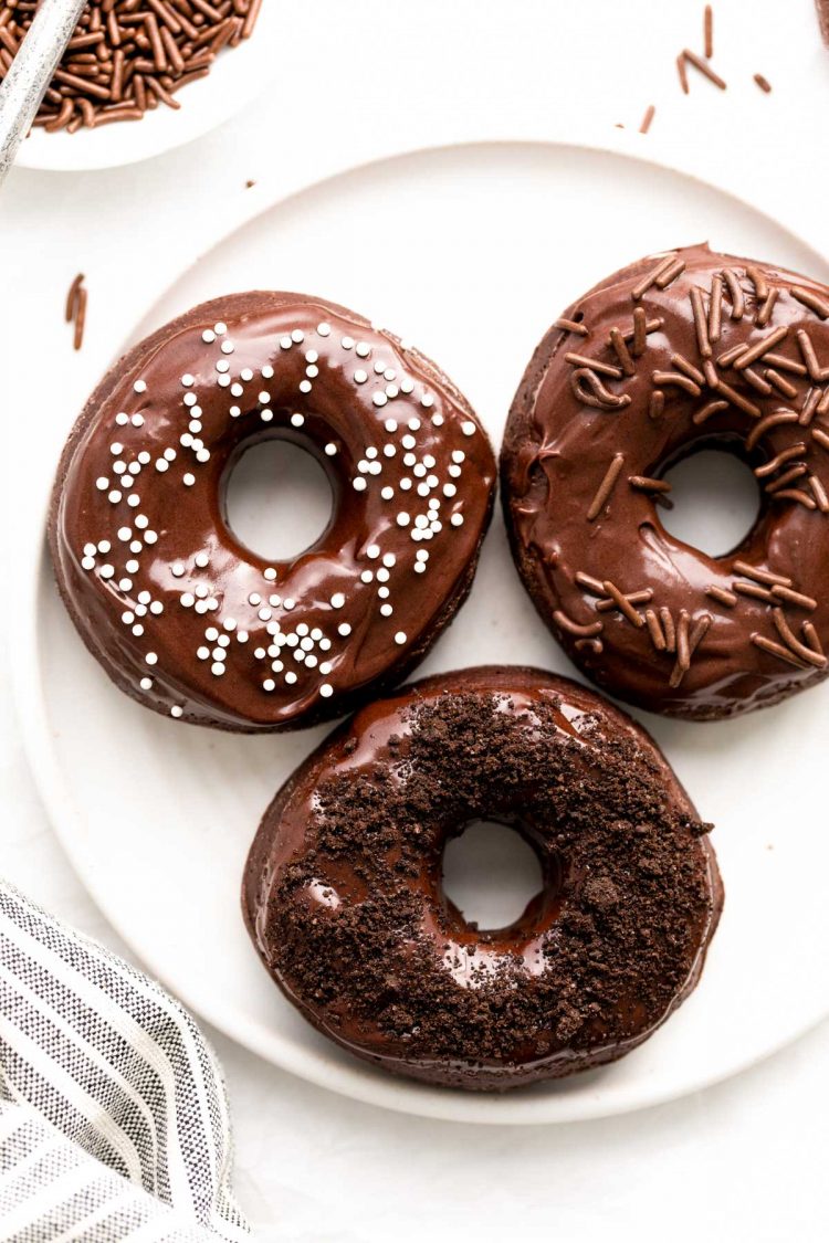 Chocolate frosting donuts on a white plate.