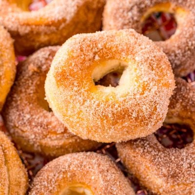 Air fryer cinnamon sugar donuts piled on a wire rack.