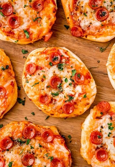 Close up photo of mini pizza on wood plate.