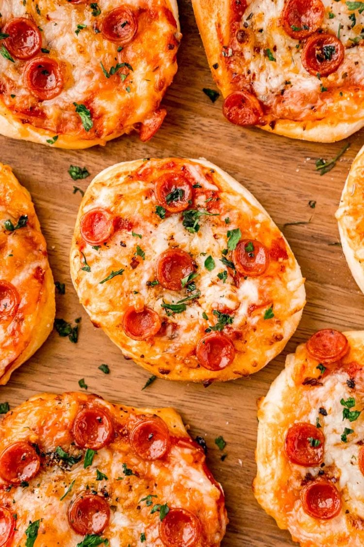 Close up photo of mini pizza on wood plate.