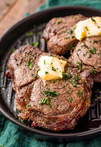 Close up photo of air fryer filet mignon on a black plate on a green napkin.