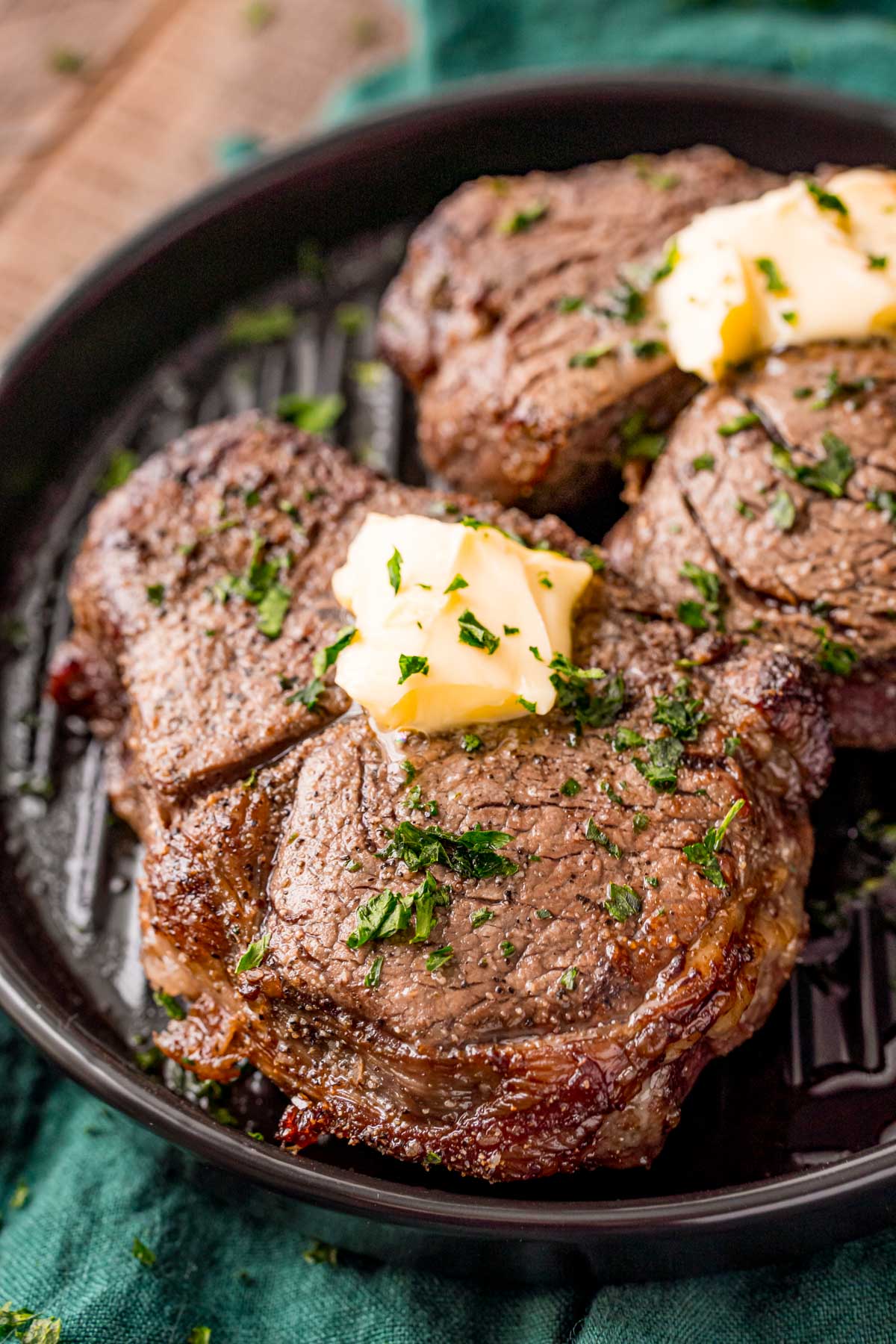 Close up photo of air fryer filet mignon on a black plate on a green napkin.