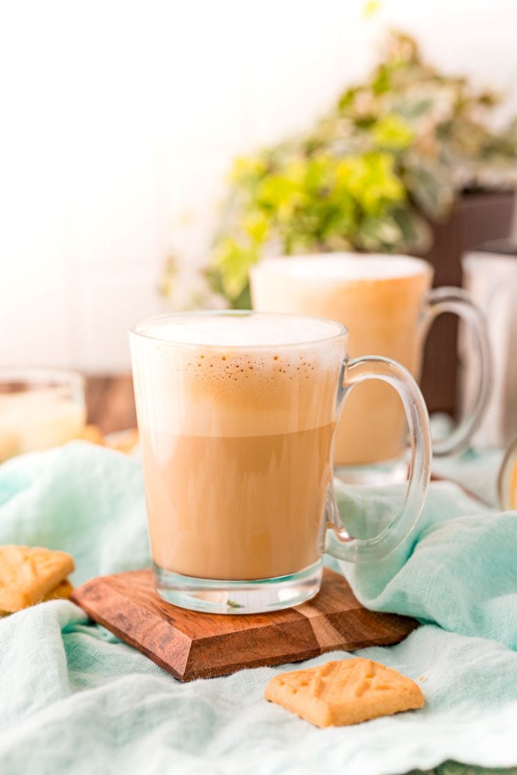 A breve latte sitting on a wooden coaster on a blue napkin.