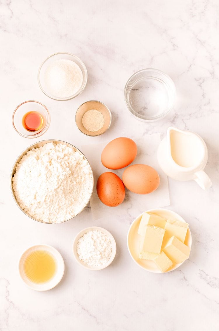 Overhead photo of ingredients needed to make donuts from scratch on a marble counter.