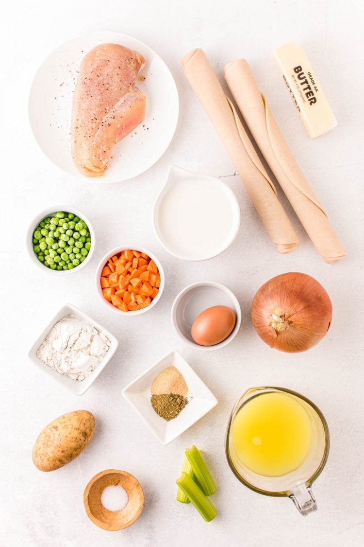 Overhead photo of ingredients to make chicken pot pie on a white counter.