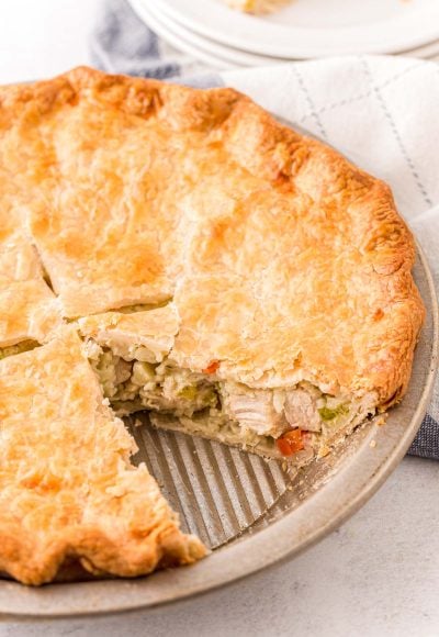 Close up photo of a chicken pot pie with a slice missing out of it.