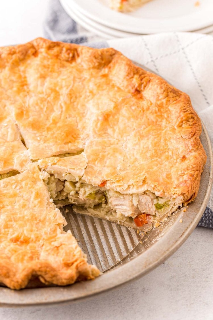 Close up photo of a chicken pot pie with a slice missing out of it.