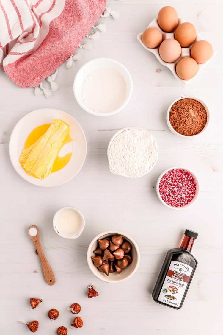 Ingredients to make chocolate hershey kiss cookies on a white counter.