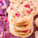 Close up photo of a stack of circus animal sugar cookies on a copper wire rack on a purple napkin.