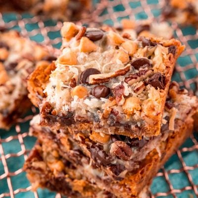 Close up photo of Hello Dolly Bars stacked on a copper wire rack.