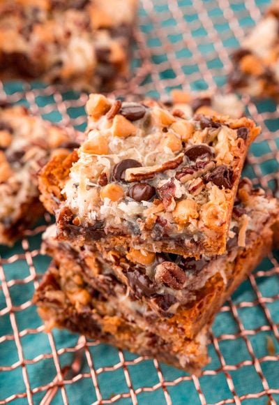 Close up photo of Hello Dolly Bars stacked on a copper wire rack.