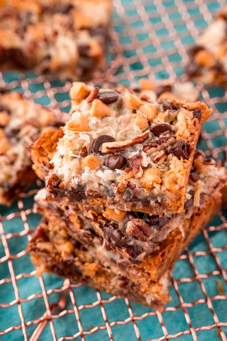 Close up photo of Hello Dolly Bars stacked on a copper wire rack.