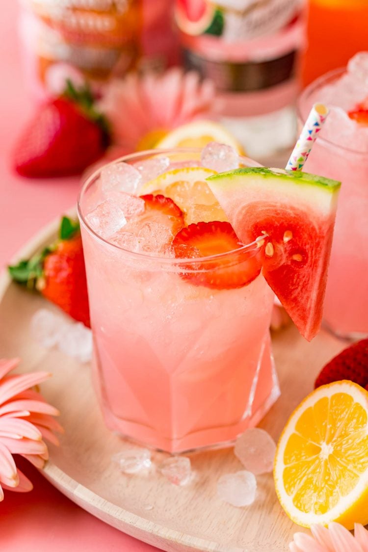 Close up photo of a glass of hippie juice garnished with watermelon and strawberries.