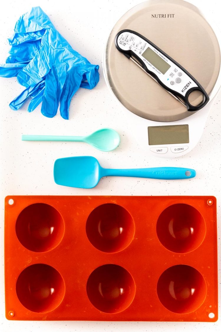 Overhead photo of tools to make hot chocolate bombs on a white table.