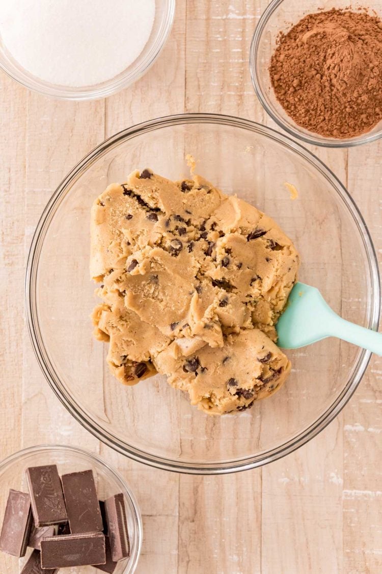 Overhead photo of ingredients to make mint chocolate chip cookies on a wooden table.