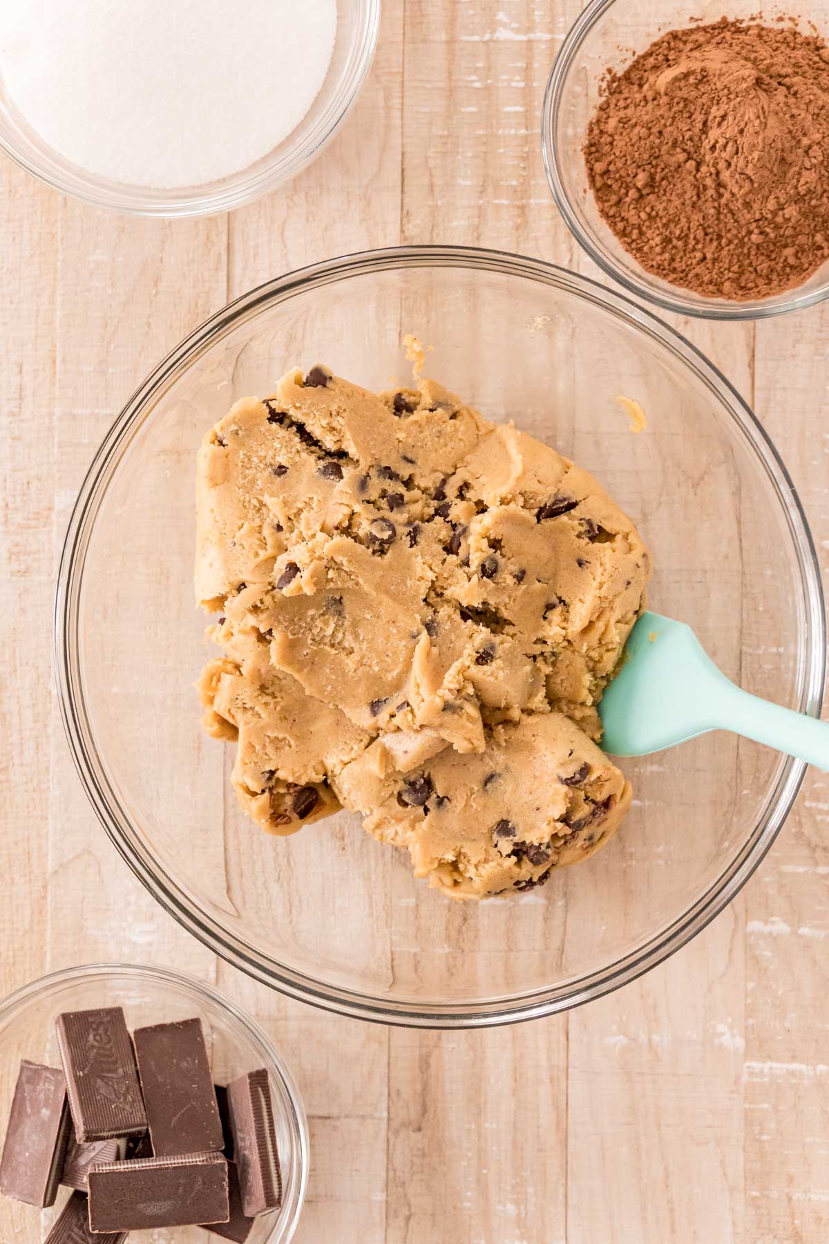 Overhead photo of ingredients to make mint chocolate chip cookies on a wooden table.