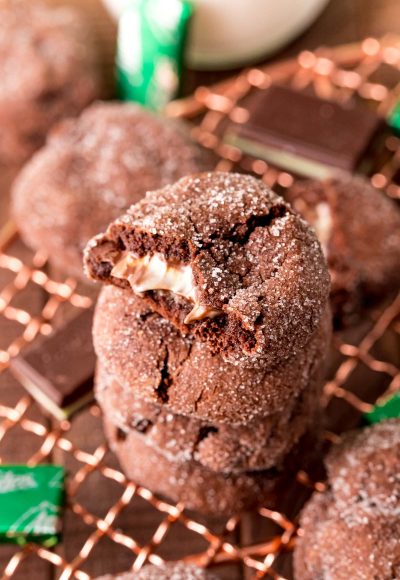 A stack of chocolate mint cookies on a cooling rack. The top on has a bite taken out of it.