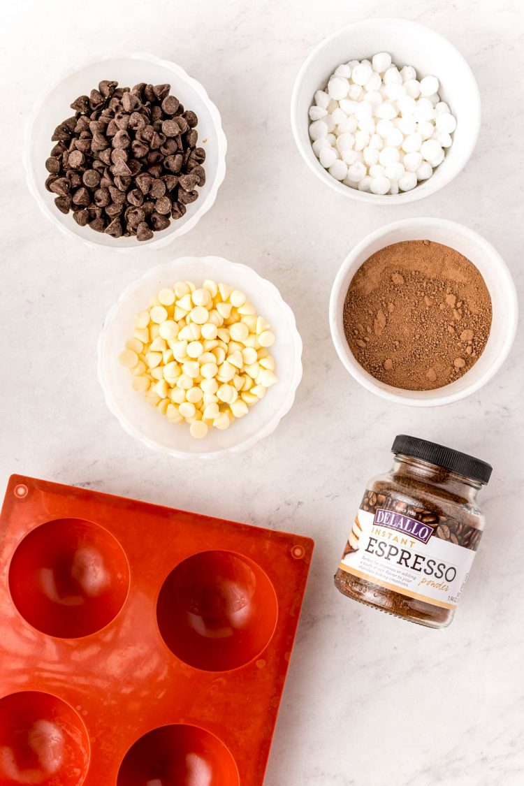 Overhead photo of ingredients to make mocha hot chocolate bombs on a white table.