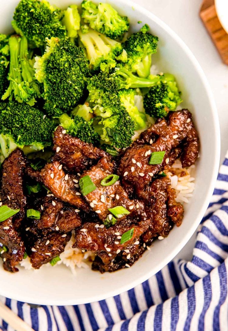 Overhead photo of mongolian beef with broccoli and rice in a white bowl.