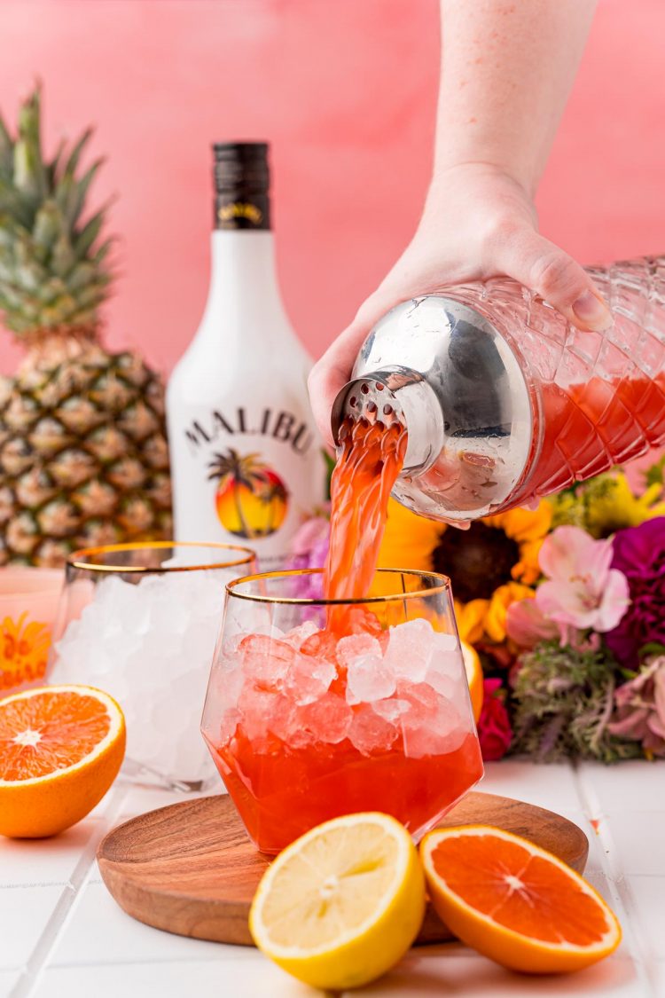 A bahama mama cocktail being strained into a glass.