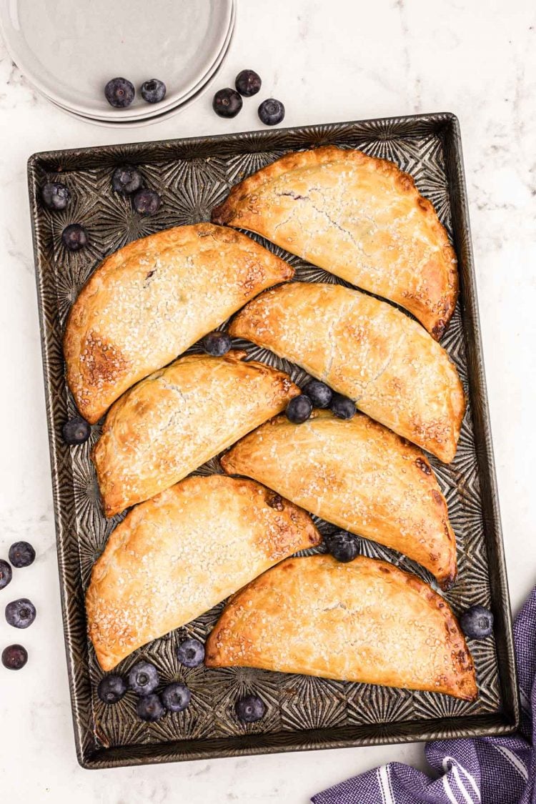 Overhead photo of blueberry hand pies on a baking dish.
