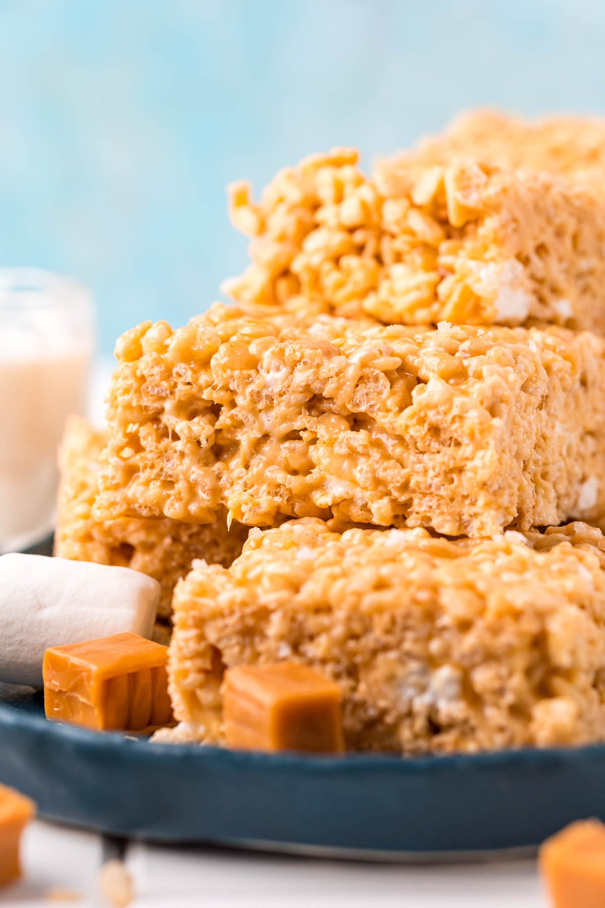 Salted caramel rice krispie treats stacked on a blue plate.