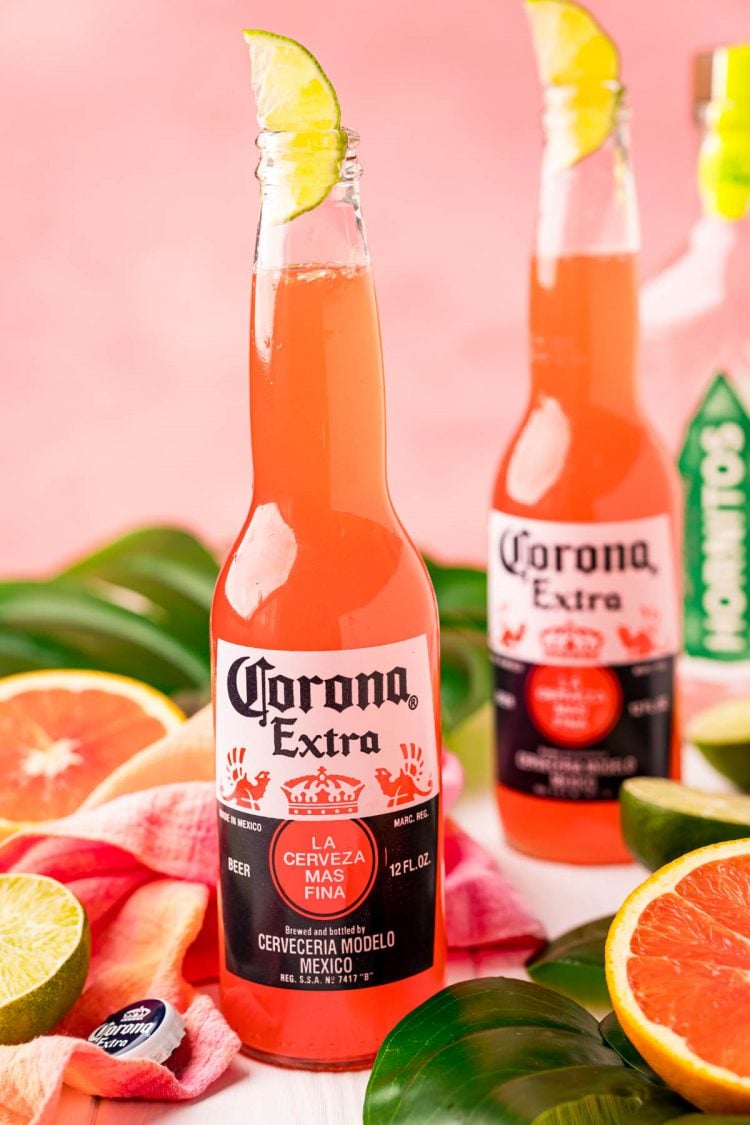 Close up photo of a Corona beer bottle with a Corona Sunrise in it and another one behind it.