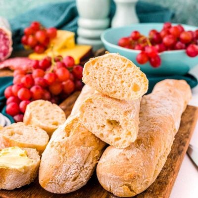 Close up photo of French baguettes on a wooden cutting board.