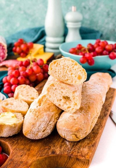 Close up photo of French baguettes on a wooden cutting board.