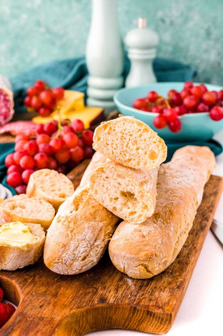 Close up photo of French baguettes on a wooden cutting board.