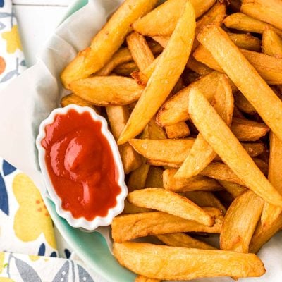 Close up overhead photo of french fries in a bowl with a mini bowl of ketchup.