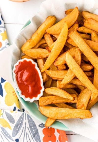 Close up overhead photo of french fries in a bowl with a mini bowl of ketchup.