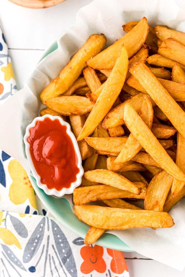 Close up overhead photo of french fries in a bowl with a mini bowl of ketchup.
