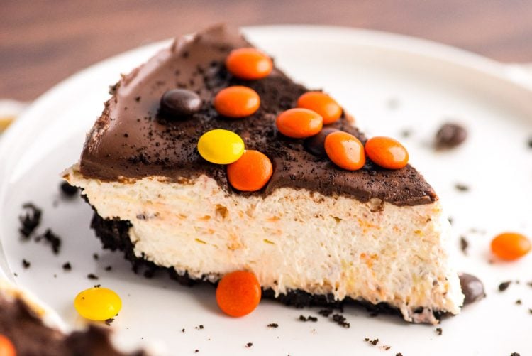 Close up photo of a slice of peanut butter cheesecake on a white plate.