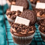 Close up of Oreo Cupcakes on a wire rack on a blue napkin.